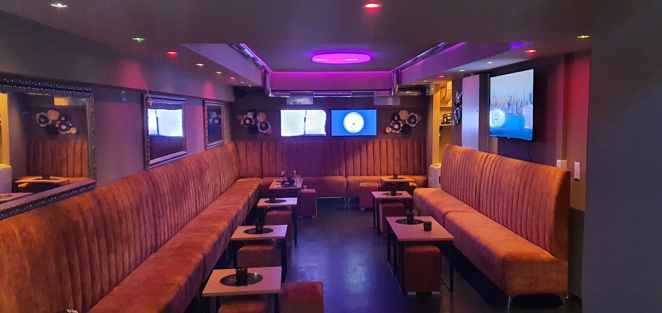 Gemütlicher Innenbereich von Edi's Bar & Lounge mit lila Ambientelicht und Lounge-Sitzecken