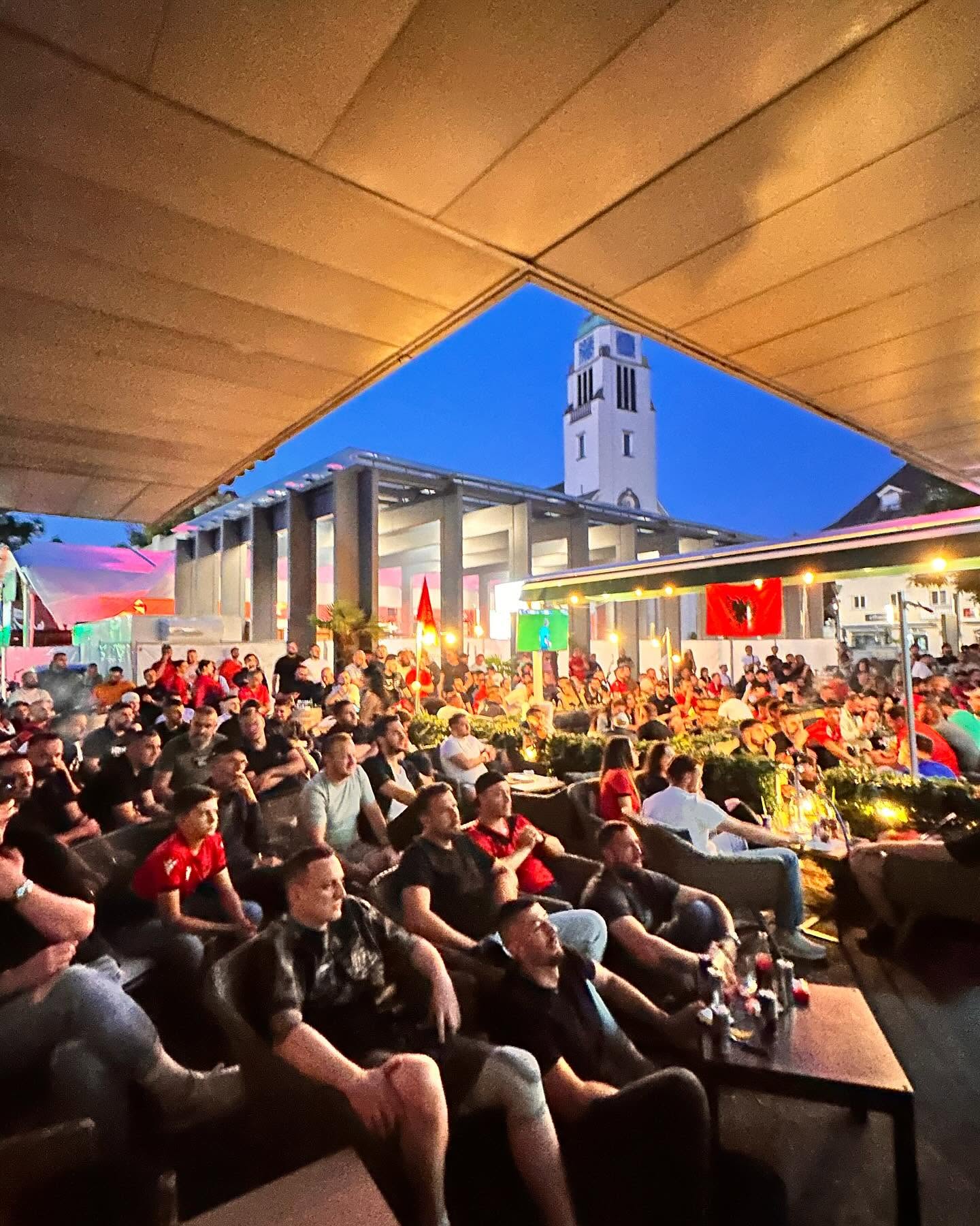 Volle Terrasse von Edi's Bar & Lounge in der Abenddämmerung mit Blick auf den Dietikoner Kirchturm